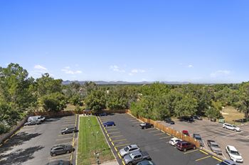 an aerial view of a parking lot with cars and trees